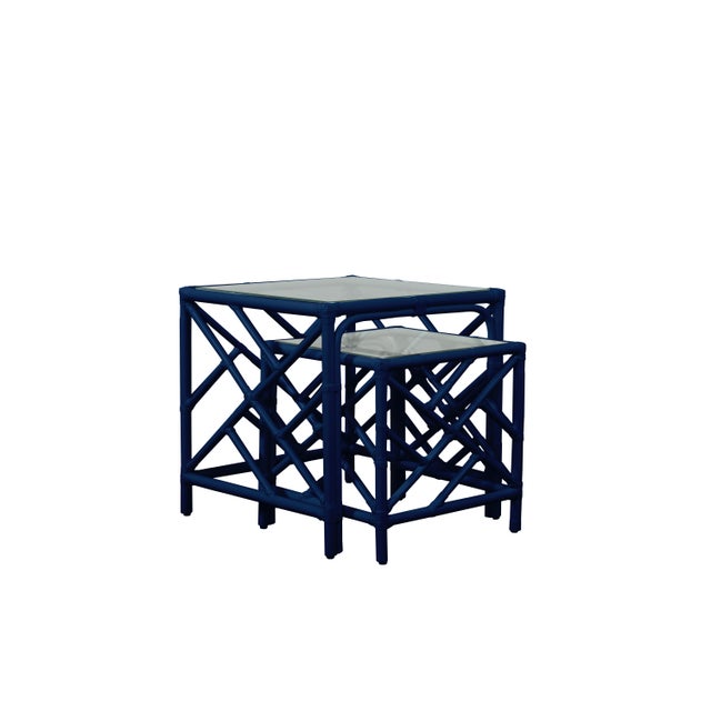 In a classic chinoiserie style, this set of two rattan nesting tables feature a rattan frame, rawhide bindings, hand...
