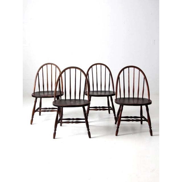 This set of four antique wooden dining chairs is crafted in the classic Windsor style, celebrated for its timeless...