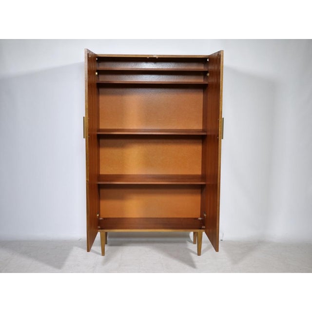 Vintage teak highboard, 1960s. A clean-lined cabinet with beautiful teak grain, slim metal handles, and tapered wooden...