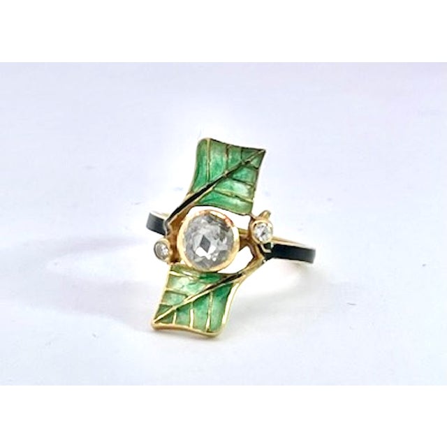 This striking Art Nouveau-style ring showcases a nature-inspired design centered on a bezel-set, old-cut diamond that...