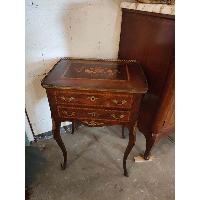Elegant French 19th-century bonheur du jour / writing table featuring a floral marquetry inlaid top framed with decorative...