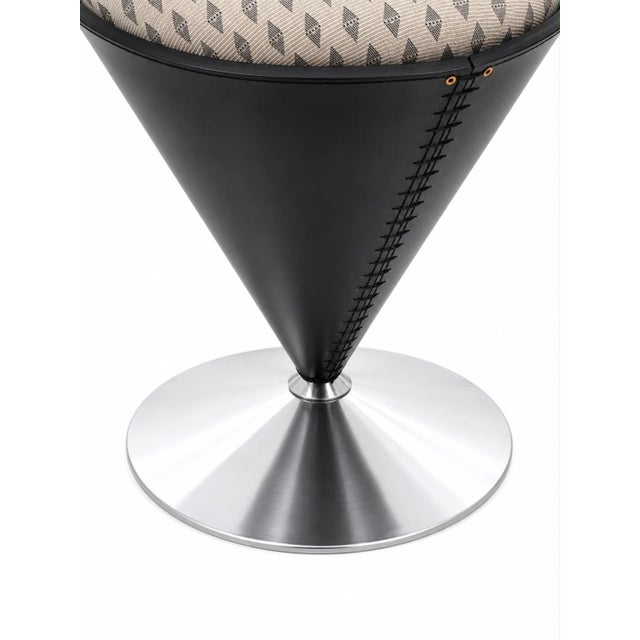 An iconic design armchair, created by Verner Panton as the "Cone Chair," with a polished stainless steel frame and black...