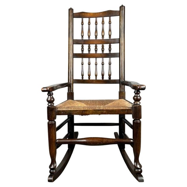 A charming early 20th century oak rocking chair, showcasing traditional craftsmanship and timeless country house appeal....