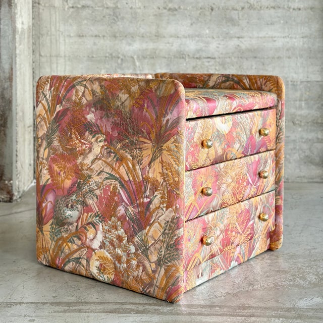 Rare upholstered vintage bedside table with golden handles and 3 drawers. This beauty screams positive energy with its...