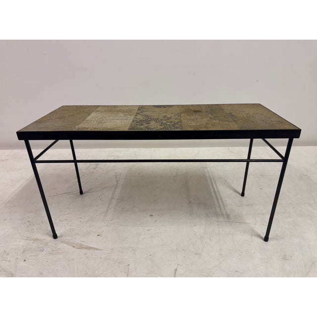 A characterful stone-topped table, likely French and dating to the 1960s, combining a richly textured surface with a...