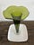This is a vintage Mid-Century Modern trumpet vase, typically featuring an emerald green glass body with a ruffled rim and...