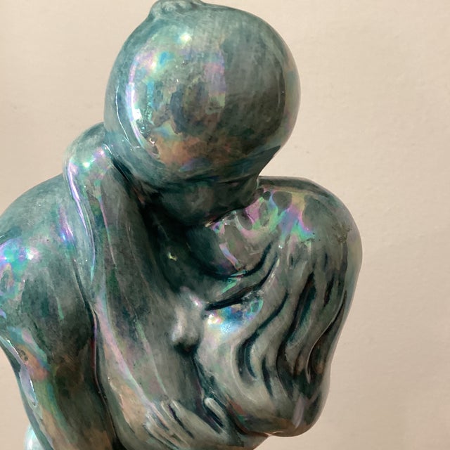 The Vintage Art Deco Inspired Ceramic Iridescent Glazed Sculpture depicting an "Embracing Couple" exudes a sense of...