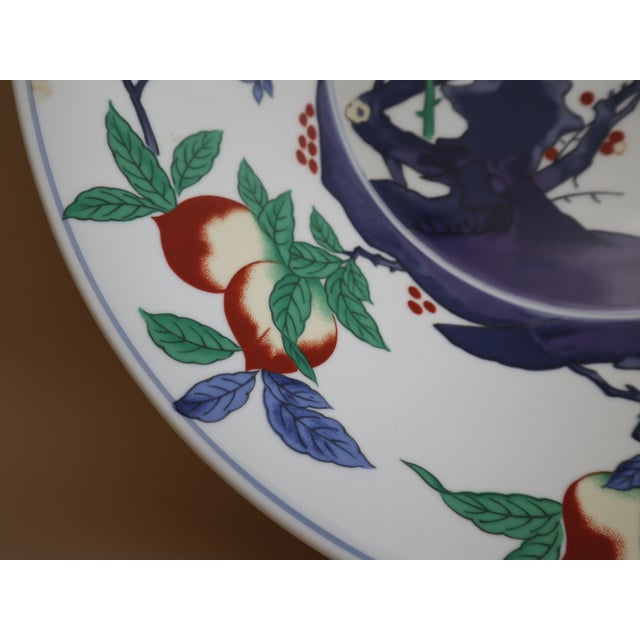 Oversized vintage painted serving bowl from China depicting outdoor landscape. Blue, green, red, and yellow colors make...