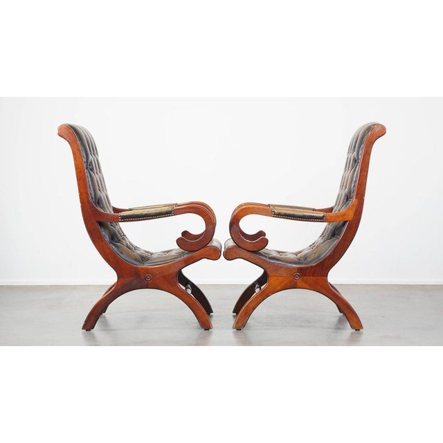 Set of 2 graceful and characterful green vintage cowhide English chesterfield armchairs combined with wood. This set of 2...