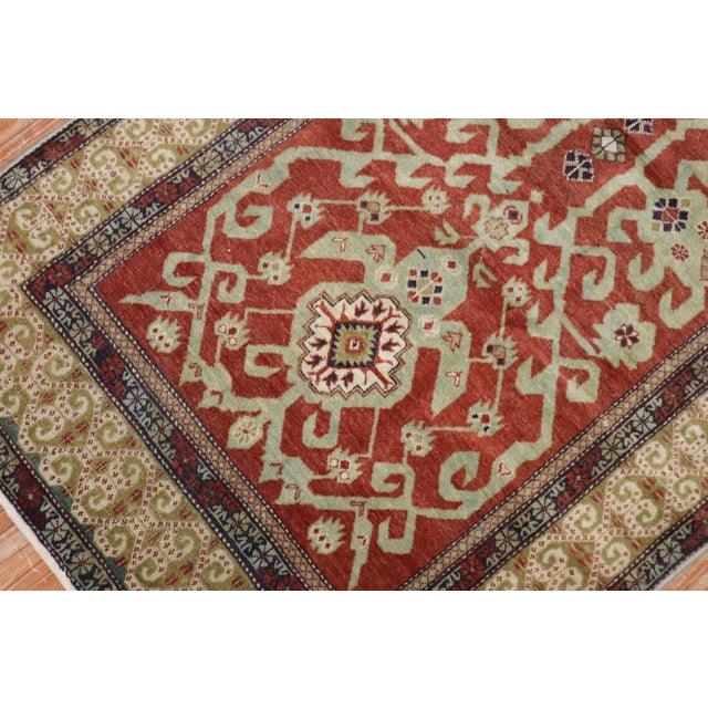 A geometric Caucasian shirvan rug from the early 20th century. Brick red field, earth accents in green and blue, circa...