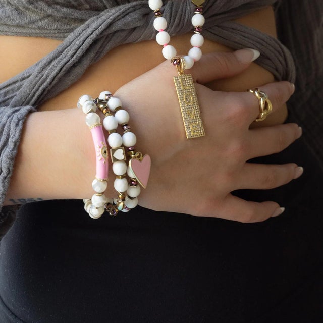 The Pink Evil Eye White Nepal Agate Beaded Love Protection Bracelet is a beautiful piece of handmade jewelry that features...