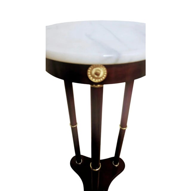 A Bombay classic traditional pedestal in mahogany and brass accents. This stand has a top of marble, white with gray...