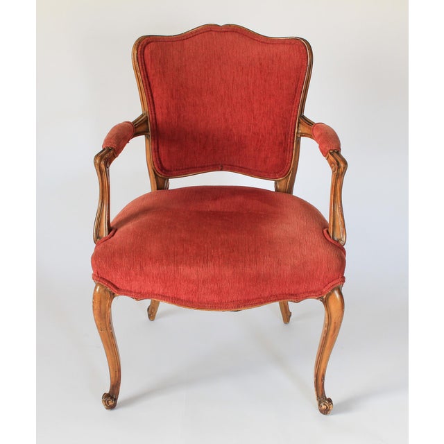 French upholstered Louis XV style fauteuil with salmon colored fabric and cabriole legs. No makers mark. Age wear to wood...