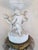 Elaborate antique porcelain and gilt-metal centerpiece featuring three finely modeled putti surrounding a classical urn...