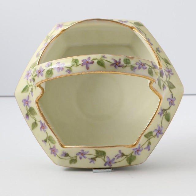 A delicate and refined antique T&V Limoges basket, beautifully hand-painted with violet garlands on a soft ivory ground,...