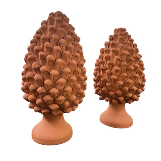 This striking pair of vintage terracotta finials features the classic pine cone motif, a timeless symbol of longevity and...