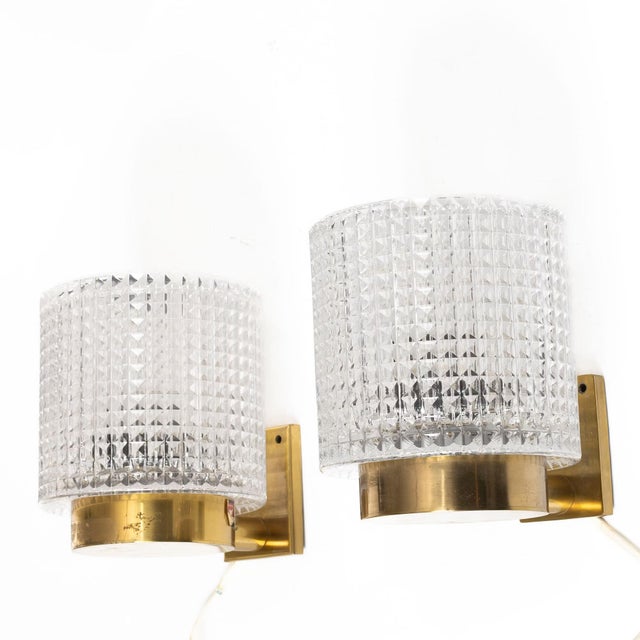 Elegant pair of sconces by Carl Fagerlund for Orrefors made in Sweden around 1960, diamond cut cast glass mounted on brass...