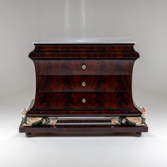 Large Empire mahogany-veneered chest of drawers raised on an exceptionally crafted base supported by chimera figures with...