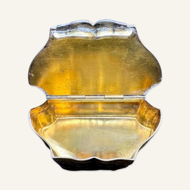 Silver pill box with gold wash interior and blue enamel and repousse decoration. The top depicts Palaimon of Greek...