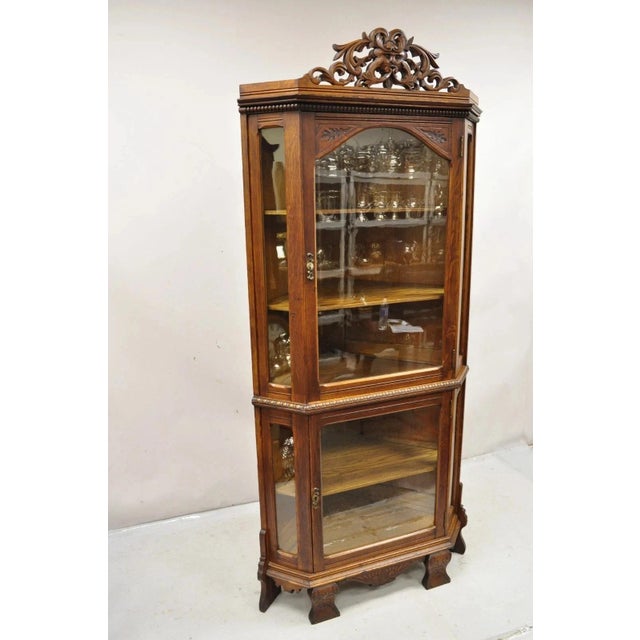 Antique Oak Victorian Renaissance Glass Door Carved Curio Corner China Cabinet. Item features carved Northwind face...
