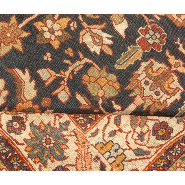 An early 20th century antique Persian Sultanabad rug, the black field having a bold allover trellis of stylized palmettes,...