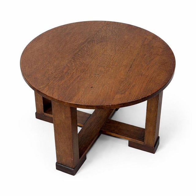 A charming Arts & Crafts circular oak low table, showcasing the honest craftsmanship and sturdy construction associated...