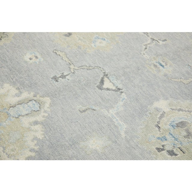 This modern Turkish Oushak rug is a stunning piece of art that has been handwoven using traditional techniques by skilled...