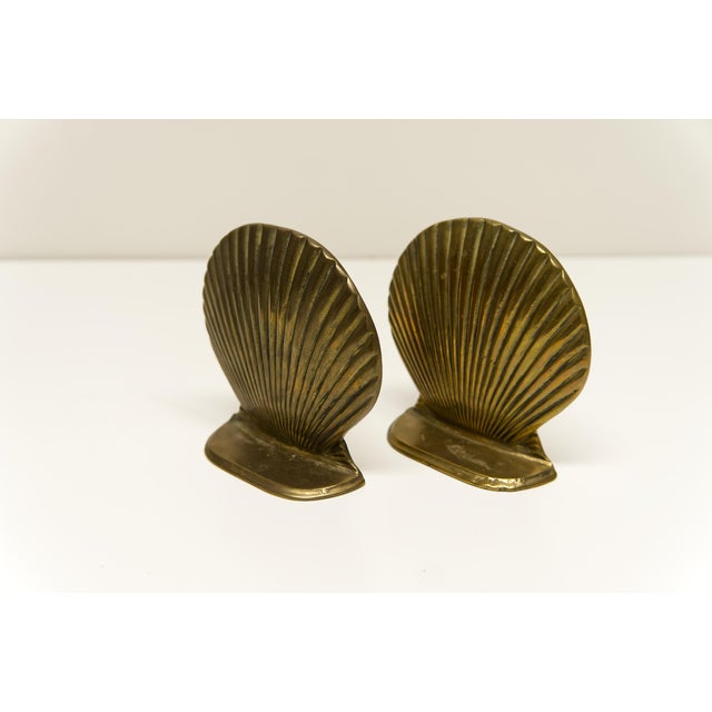 A pair of vintage cast brass seashell shape bookends. Stamped on the bottom with maker's mark and provenance.