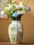 Elegant vintage Chinoiserie ceramic vase featuring a classic green and white color palette. The piece displays traditional...