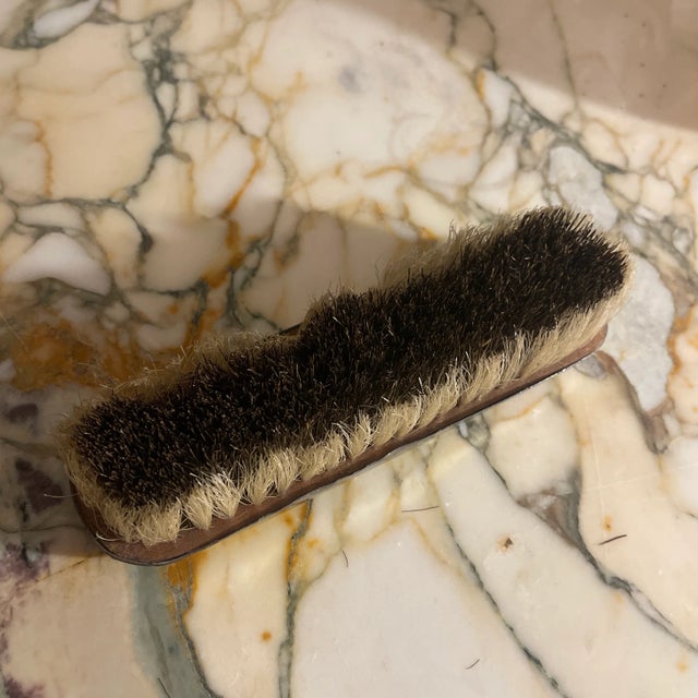 A beautiful clothing brush with an ornate design of flowers and holly