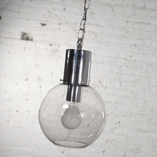 Handsome mid-century modern chrome and lightly smoked glass open globe pendant light with chrome chain. It is in wonderful...
