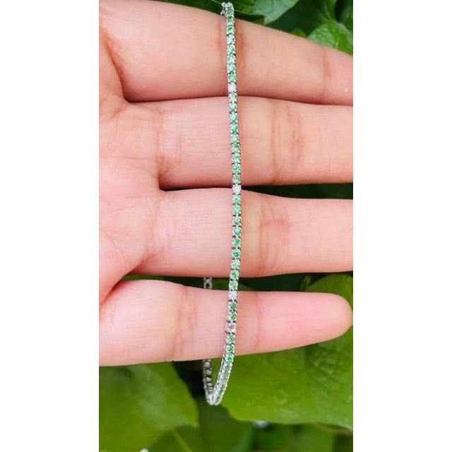 This is part of Chairish’s Fine Jewelry assortment. This Round-Cut Tsavorite Diamond Tennis Bracelet in 18K gold showcases...