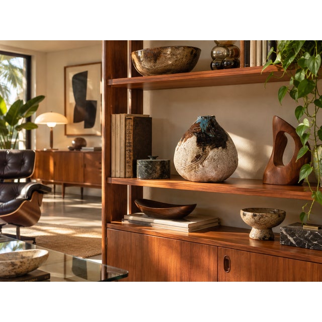 Featuring a rounded teardrop form, textured glaze, and abstract brown, black, and blue accents. A distinctive decorative...