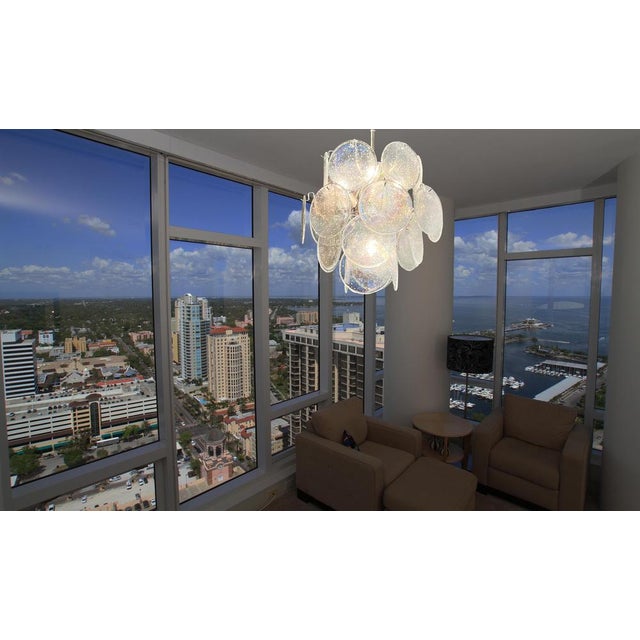 Vintage Italian Murano chandelier in Vistosi style. The chandelier has 24 fantastic iridescent grit discs in a nickel...