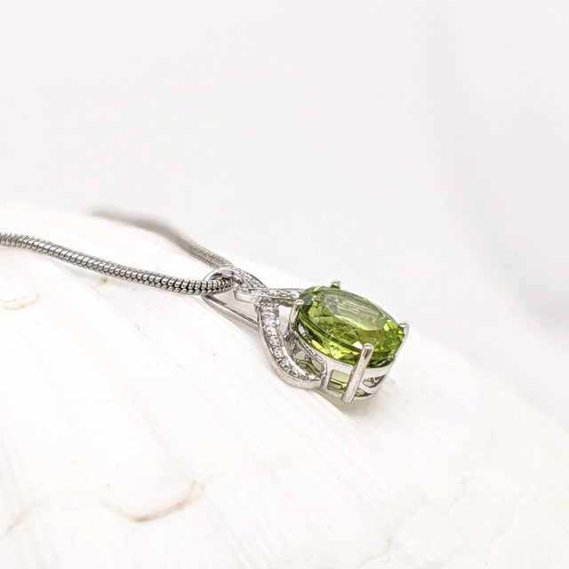 This eye-catching infinity pendant features a breathtaking oval 4.45 carat peridot with natural earth-mined diamonds. Set...