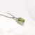 This eye-catching infinity pendant features a breathtaking oval 4.45 carat peridot with natural earth-mined diamonds. Set...