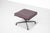 Soft pad chair ottoman stool, model "ea 223 - lounge," in plum-colored leather with red stitching, on a matte black...