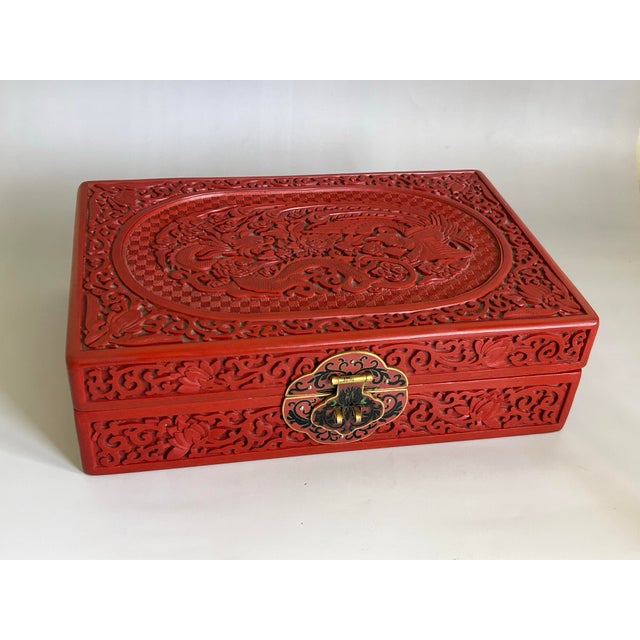A finely carved Chinese cinnabar lacquer jewelry box dating to the 1950s–1960s export period, featuring elaborate dragon...