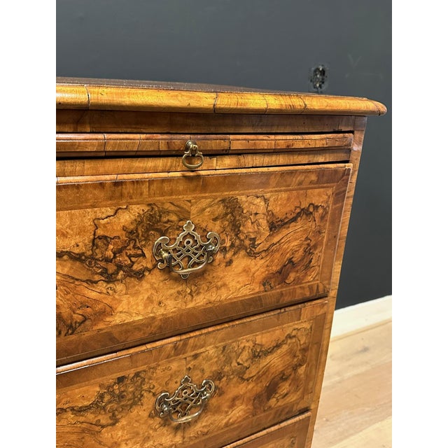 A unique 18th-century burl walnut chest of drawers, the bottom drawer featuring a sunburst inlay. A beautiful detail. The...