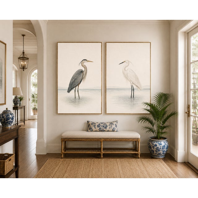 A refined coastal diptych featuring a great blue heron and a white egret standing in tranquil shoreline waters. Designed...
