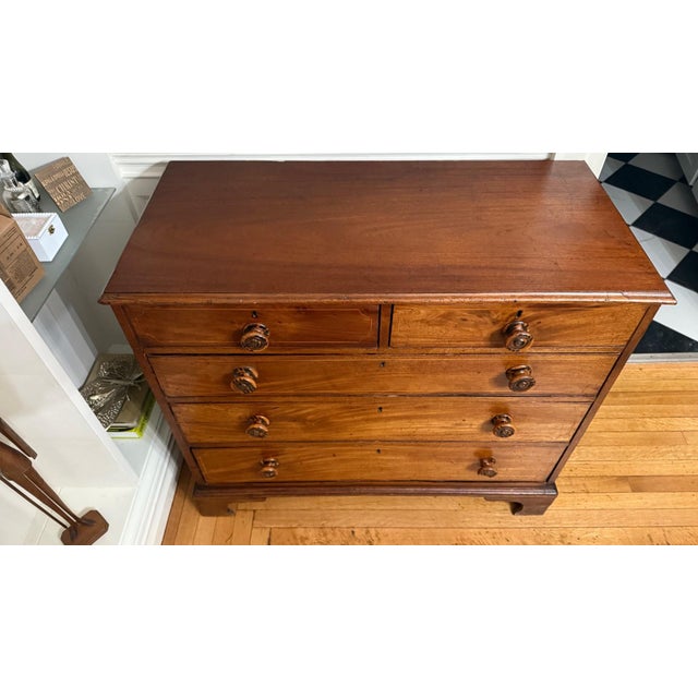 A handsome mid-19th century English chest of drawers, crafted in warm mahogany with fine linear inlay detailing on each...