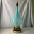 This vintage mid-century modern Murano art glass table lamp features a bulbous turquoise blue opaline body mounted on a...