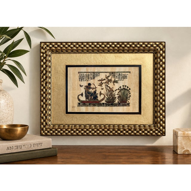 Vintage Egyptian Revival papyrus artwork depicting a traditional Nile marsh hunting scene. A standing hunter draws his bow...