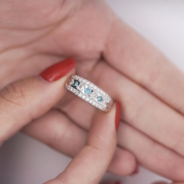 1.16 carats of white and blue round cut diamonds arranged in a gorgeous graduated three row pattern. The diamonds are set...