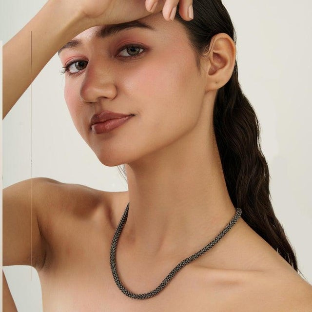 A refined blue sapphire tennis necklace crafted in 925 sterling silver, featuring finely set round-cut gemstones measuring...