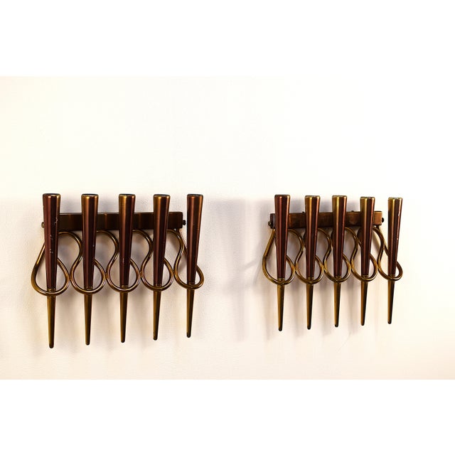 A pair of wall lamps attributed to Gio Ponti, an Italian design from the 1950s, crafted from brass and copper. The refined...