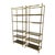 A pair of Billy Baldwin style étagères featuring clean-lined brass frames supporting graduated smoked glass shelves. The...
