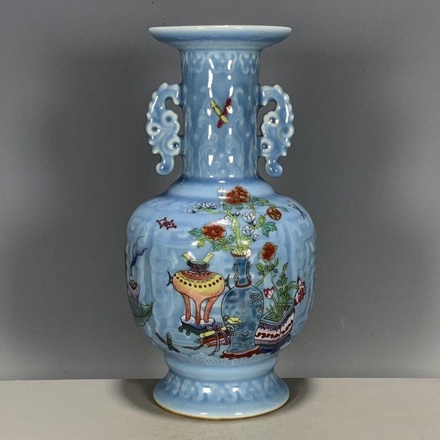 A beautiful Chinese porcelain vase featuring a light blue glazed ground with a subtle incised wave pattern. The vase has a...