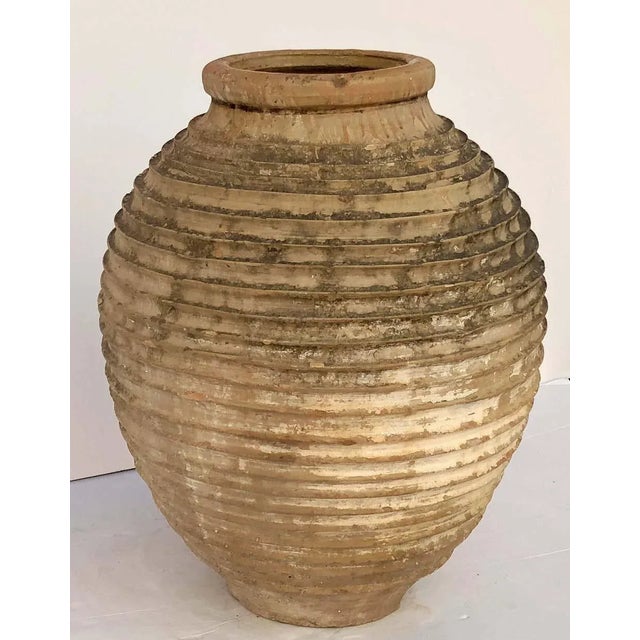 A handsome large Greek garden urn pot (Amphora) or oil jar, featuring a glazed top over a ridged, cylindrical body and...