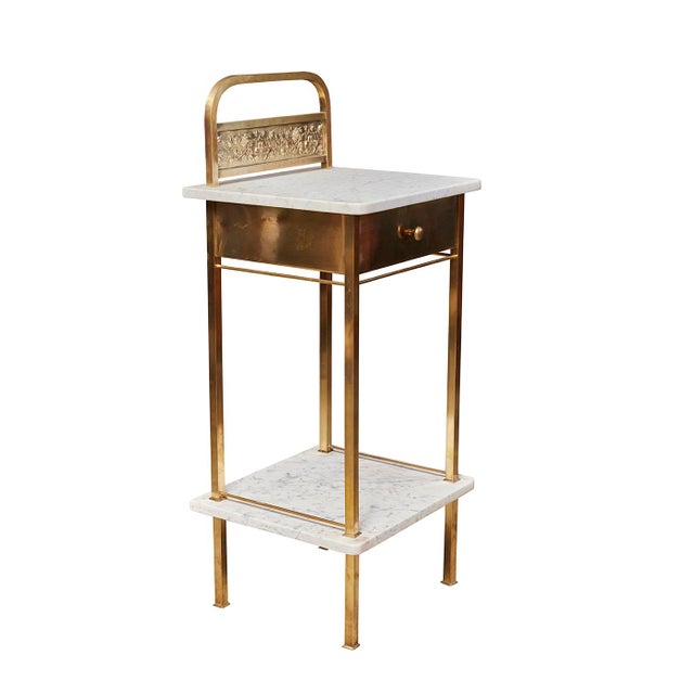 This gorgeous night stand has a beautifully repoussed brass panel with a flora and fauna motif. The piece has one drawer...